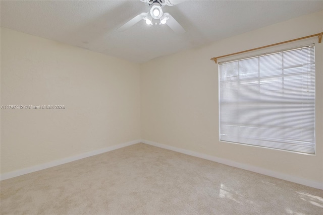 empty room featuring a ceiling fan, carpet flooring, a textured ceiling, and baseboards