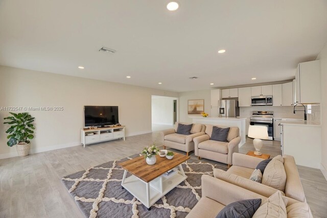 610 N 31st Ct, Hollywood, FL 33021 - living area featuring recessed lighting, light wood-type flooring, and baseboards