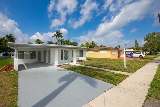 610 N 31st Ct, Hollywood, FL 33021 - view of front of property with concrete driveway, a front yard, stucco siding, and a carport