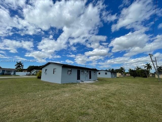 back of house featuring a yard and stucco siding