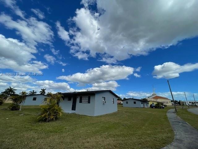 view of side of property featuring stucco siding and a yard