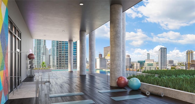 workout area with a view of city, wood finished floors, and floor to ceiling windows