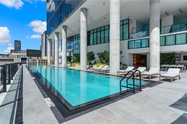 pool with a view of city and a patio area