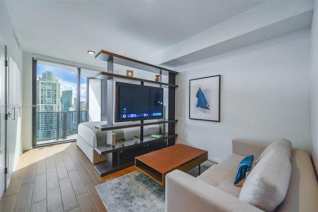 living room featuring a wall of windows and wood finished floors