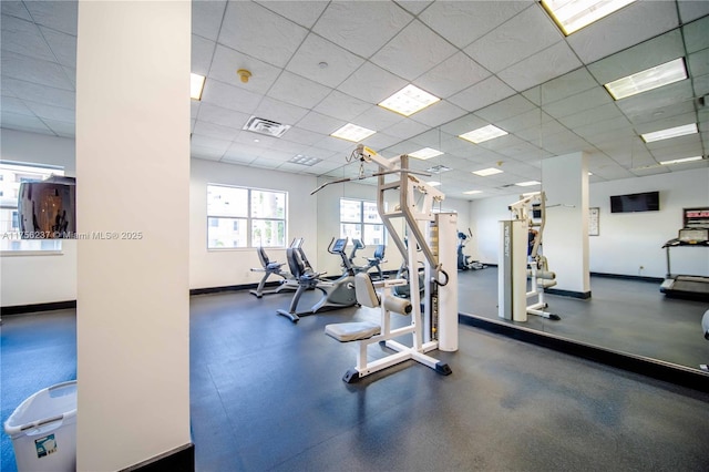 workout area featuring baseboards, visible vents, and a drop ceiling