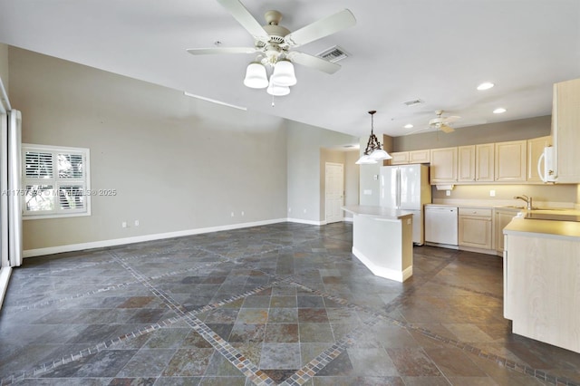 kitchen featuring white appliances, a kitchen island, visible vents, baseboards, and light brown cabinetry