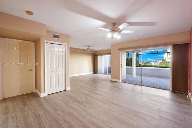 unfurnished room featuring light wood-style floors, baseboards, visible vents, and a ceiling fan