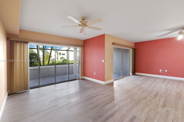 empty room featuring a ceiling fan, baseboards, and wood finished floors