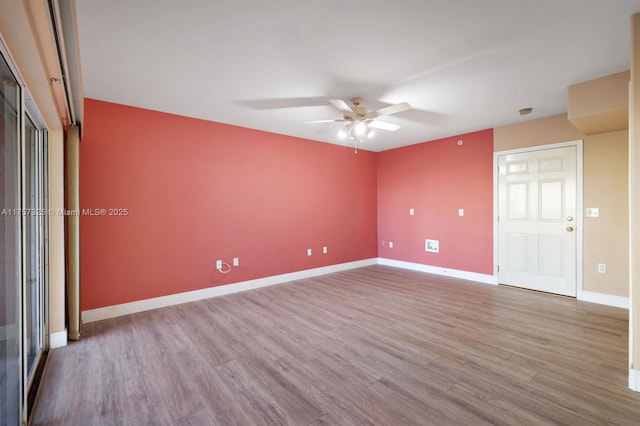 unfurnished room with a ceiling fan, baseboards, and wood finished floors