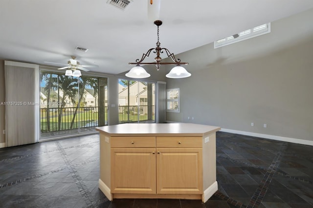 kitchen featuring baseboards, visible vents, a center island, decorative light fixtures, and light brown cabinetry