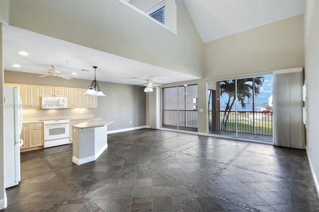 kitchen with recessed lighting, white appliances, a towering ceiling, baseboards, and light countertops