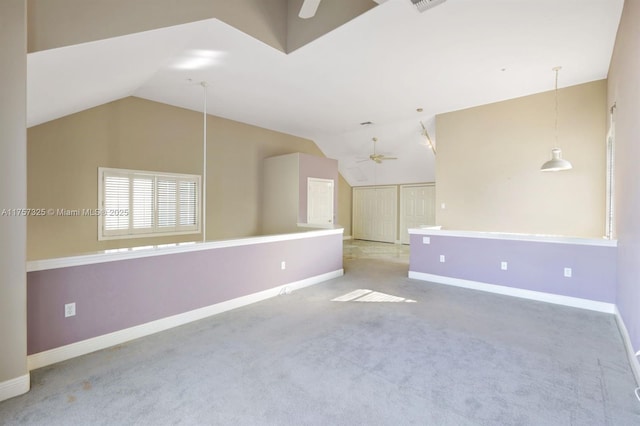 carpeted empty room with ceiling fan, vaulted ceiling, and baseboards