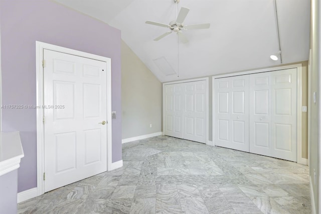 unfurnished bedroom featuring lofted ceiling, two closets, a ceiling fan, and baseboards