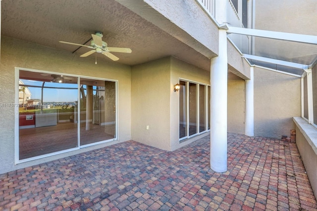 view of patio with a ceiling fan and a lanai