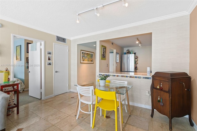 dining space featuring a textured ceiling, visible vents, and crown molding