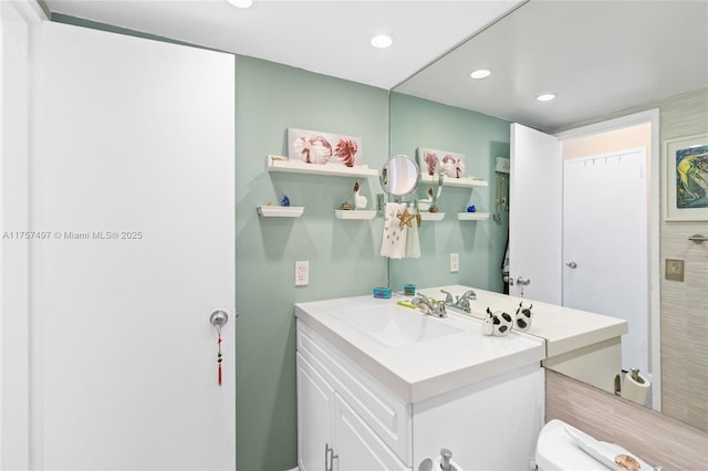 bathroom featuring vanity, toilet, and recessed lighting