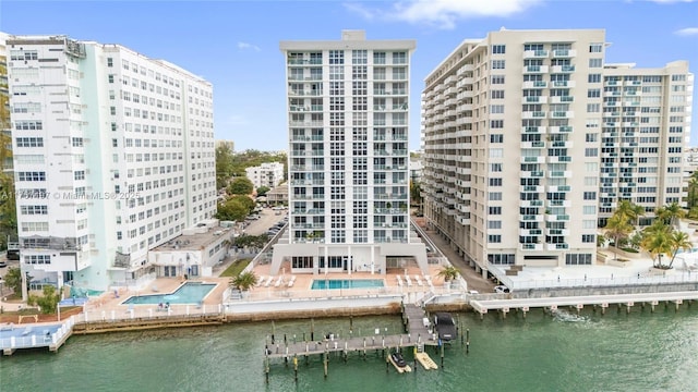 view of building exterior featuring a water view and a community pool