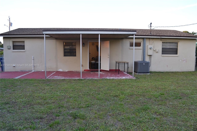 rear view of house with a patio, a lawn, cooling unit, and stucco siding