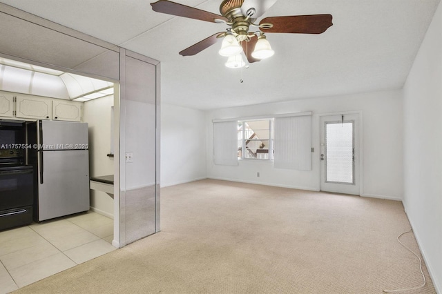 interior space with light carpet, light tile patterned floors, and a ceiling fan