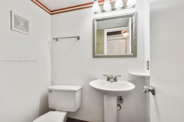 bathroom with toilet and crown molding