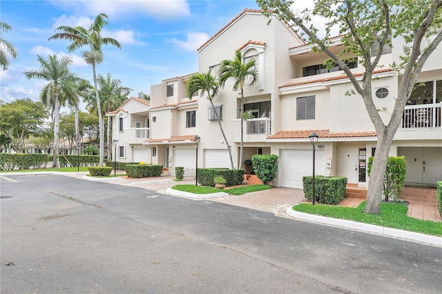 view of property with a residential view, decorative driveway, and an attached garage