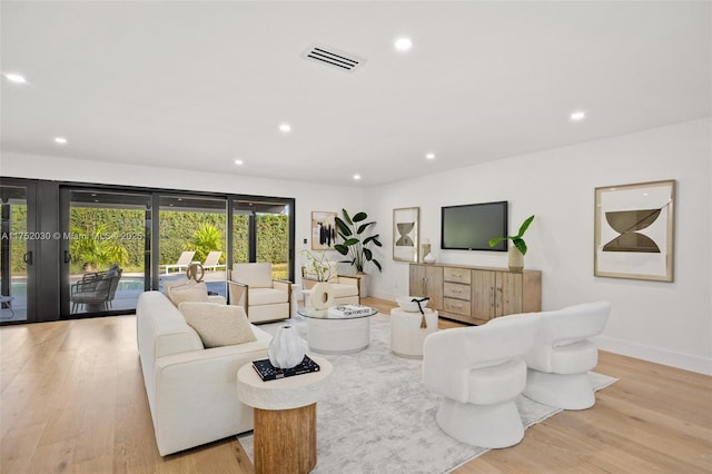 living area with recessed lighting, visible vents, baseboards, and wood finished floors