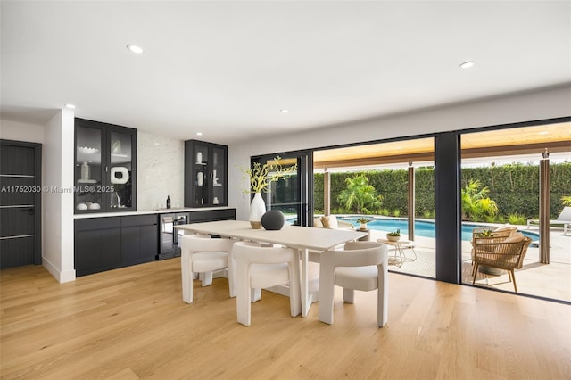 dining room with a wealth of natural light, light wood-style flooring, and wine cooler