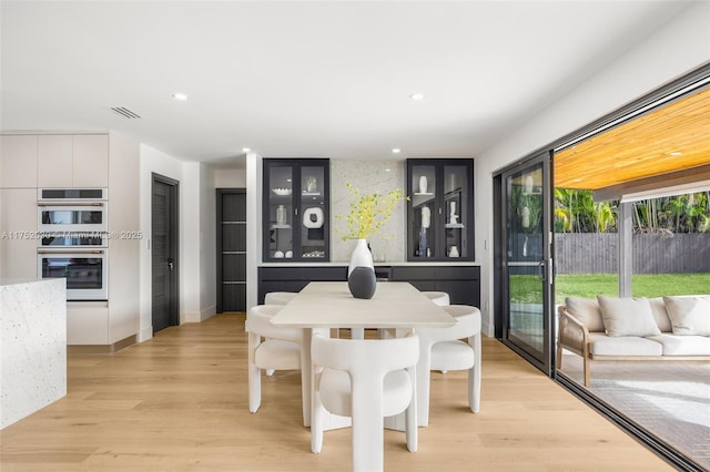 dining room featuring visible vents, light wood-style flooring, and recessed lighting