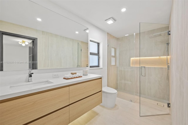 full bathroom featuring vanity, a shower stall, toilet, and recessed lighting