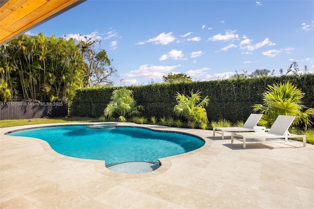 view of pool with a fenced backyard, a pool with connected hot tub, and a patio