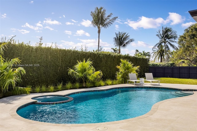 view of pool with a pool with connected hot tub, fence, and a patio