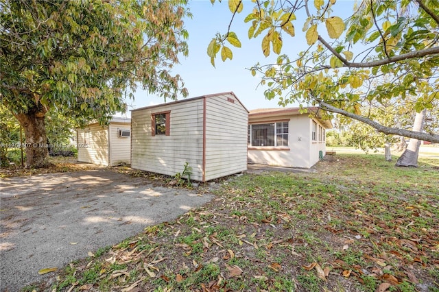 exterior space featuring aphalt driveway and an outdoor structure