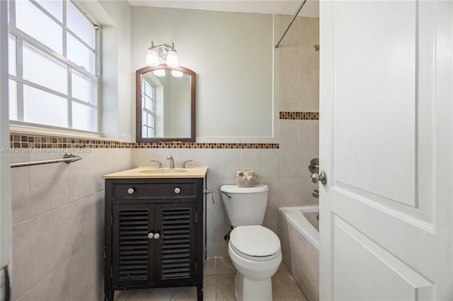 full bath featuring toilet, vanity, shower / bathing tub combination, tile patterned floors, and tile walls