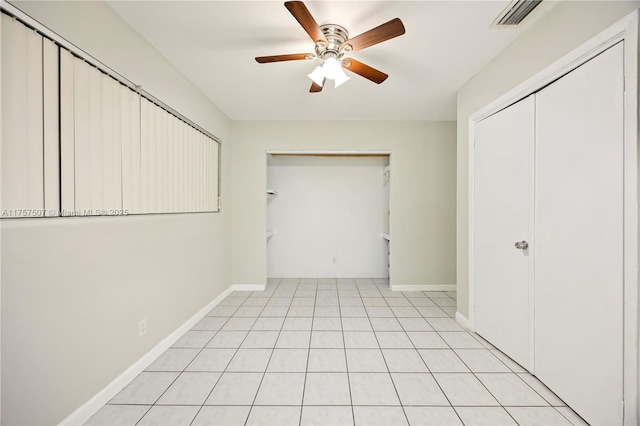 unfurnished bedroom featuring a ceiling fan, light tile patterned floors, baseboards, and visible vents