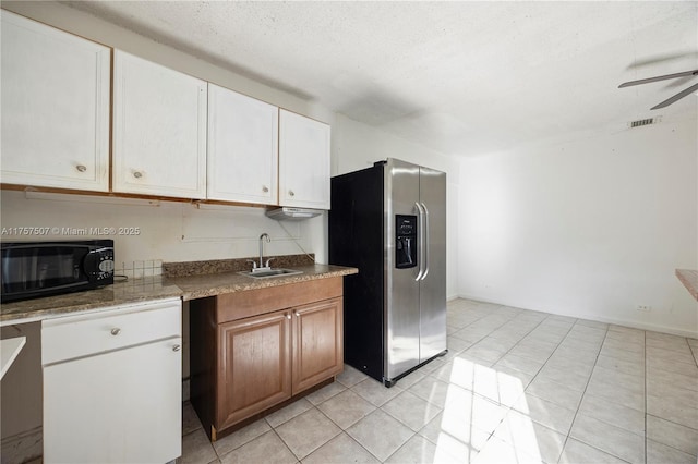 kitchen featuring ceiling fan, black microwave, stainless steel fridge with ice dispenser, light tile patterned floors, and a sink