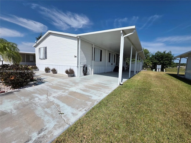 view of side of home featuring a yard, driveway, and a carport
