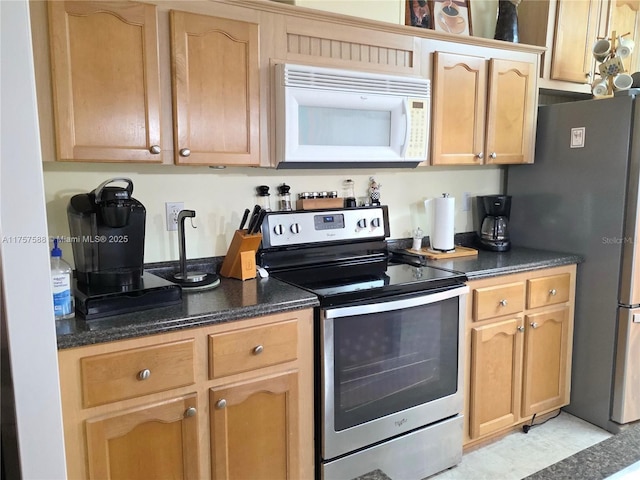 kitchen with appliances with stainless steel finishes and dark stone countertops