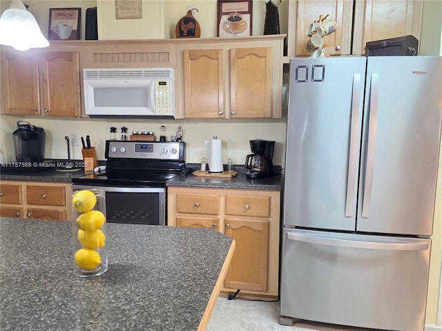 kitchen featuring appliances with stainless steel finishes, light brown cabinetry, and dark countertops