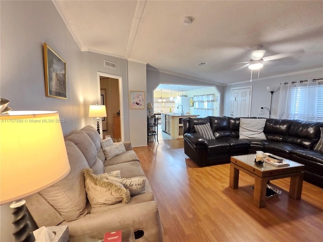 living area featuring crown molding, a ceiling fan, a wealth of natural light, and light wood-type flooring