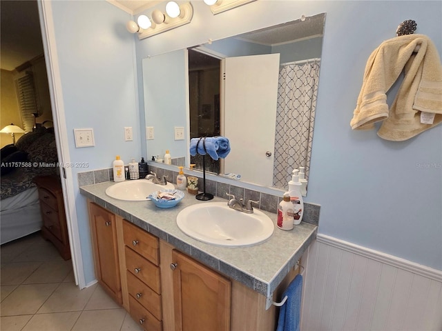 ensuite bathroom with a sink, tile patterned flooring, ensuite bath, and double vanity