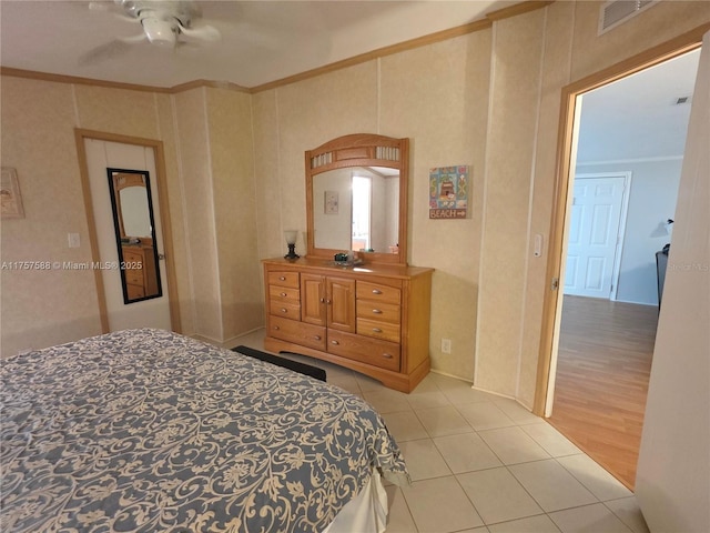 bedroom with crown molding, light tile patterned flooring, and visible vents
