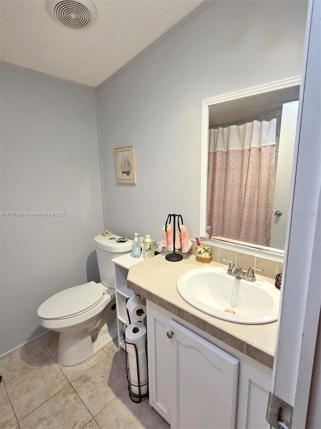 bathroom with tile patterned flooring, vanity, toilet, a shower with shower curtain, and visible vents