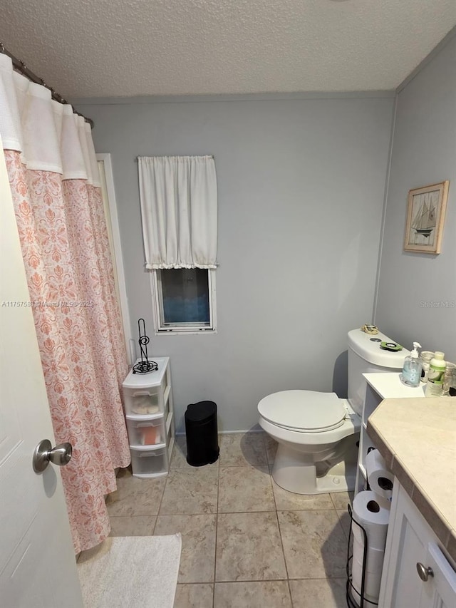 bathroom with vanity, toilet, a textured ceiling, tile patterned floors, and a shower with curtain