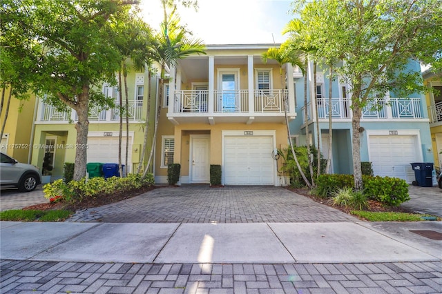 multi unit property featuring a garage, decorative driveway, and stucco siding