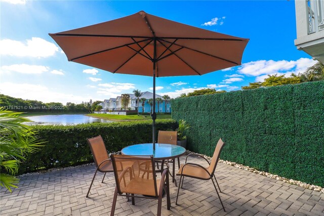 view of patio with outdoor dining area and a water view