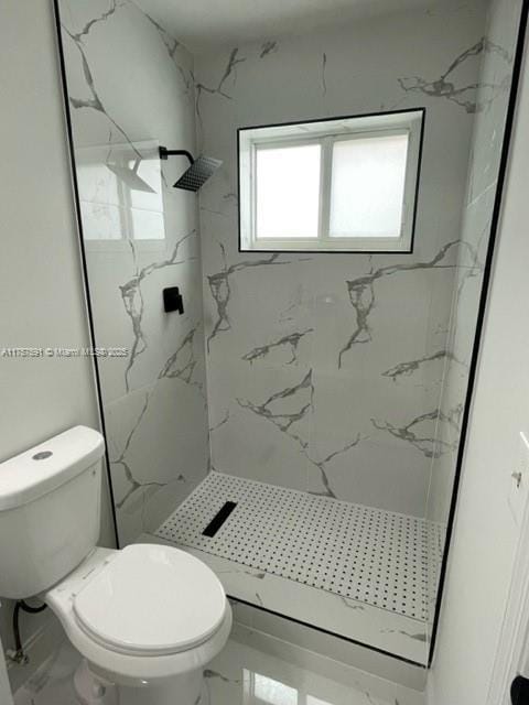 bathroom with marble finish floor, toilet, and a marble finish shower