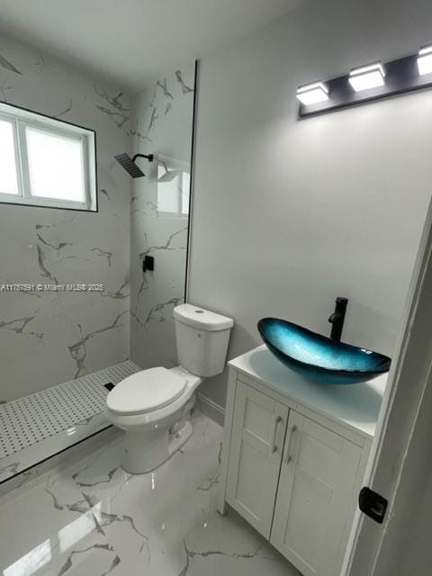 full bath featuring toilet, marble finish floor, a marble finish shower, and vanity