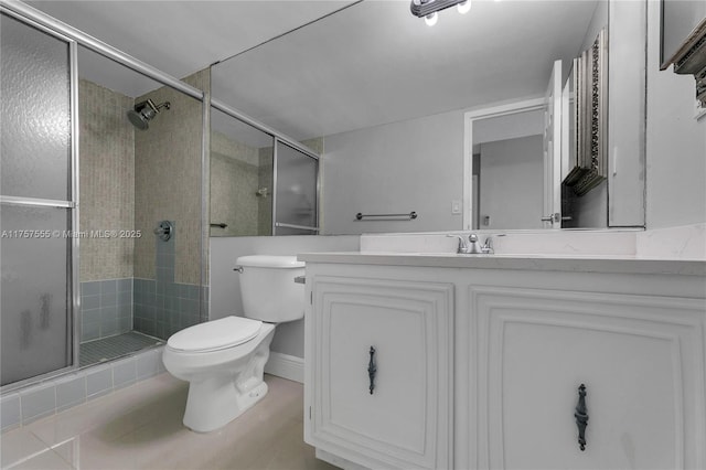 bathroom featuring toilet, a stall shower, and vanity