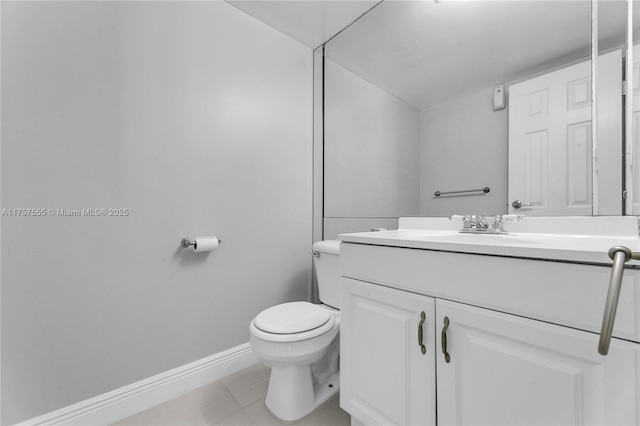 bathroom featuring baseboards, vanity, toilet, and tile patterned floors