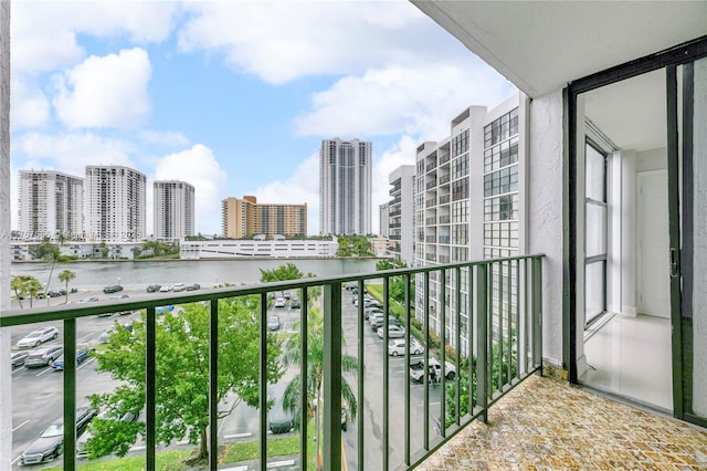 balcony featuring a water view and a city view